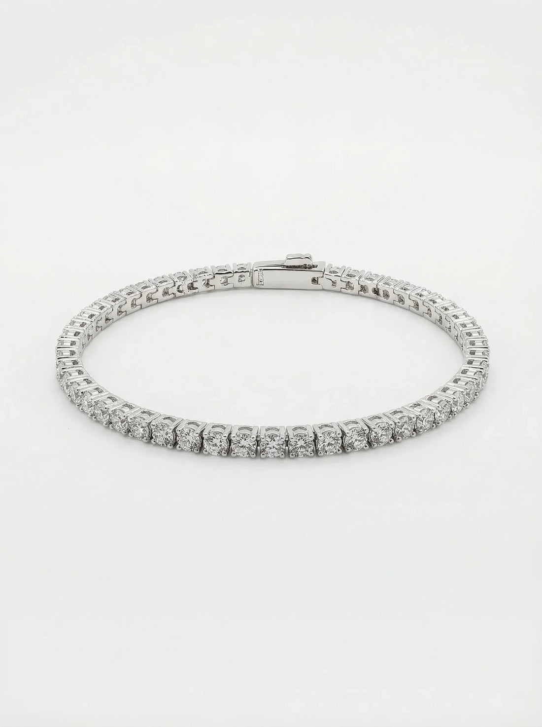 A diamond tennis bracelet in a silver-toned metal setting, photographed on a clean white background.