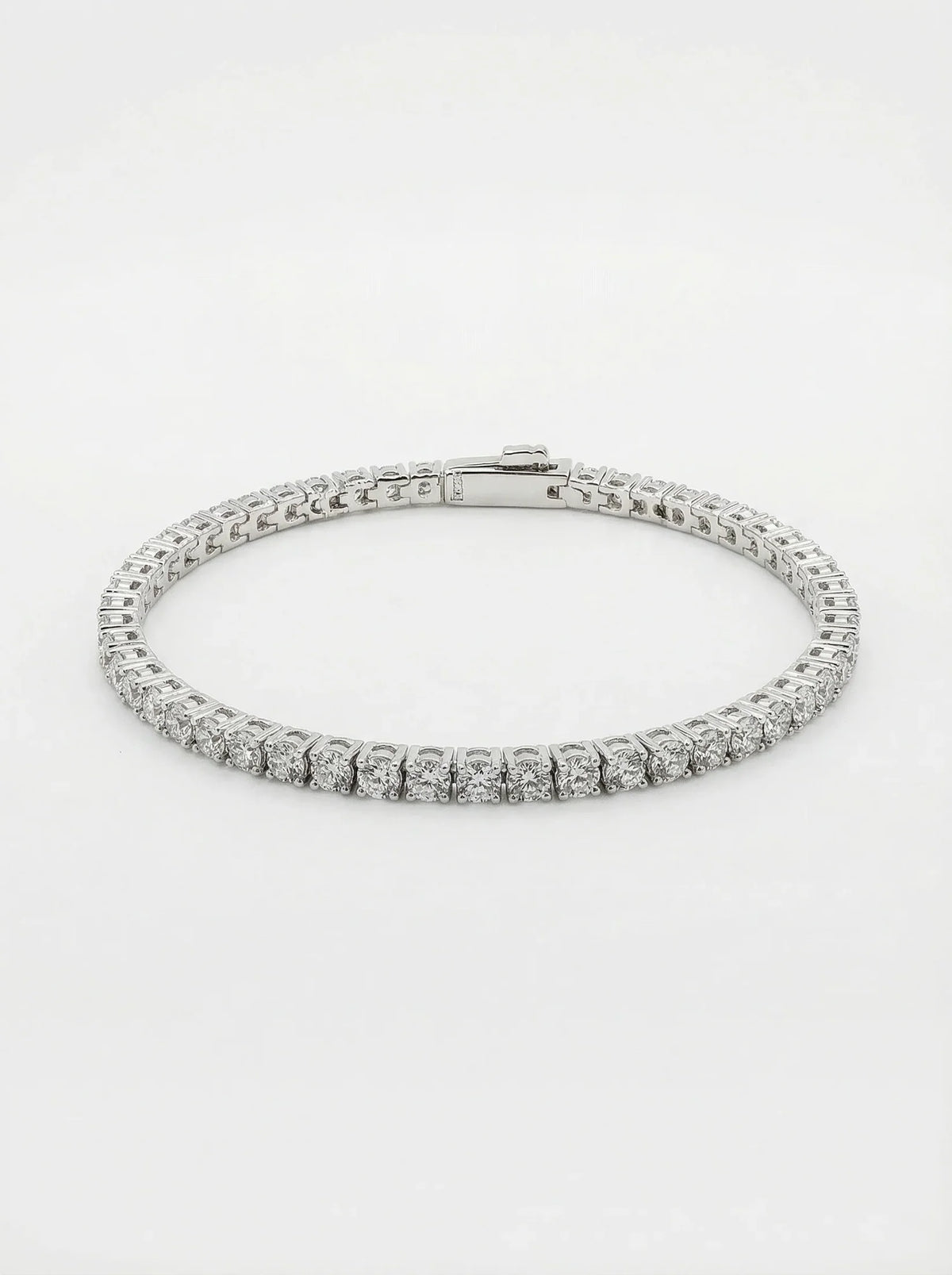 A diamond tennis bracelet in a silver-toned metal setting, photographed on a clean white background.