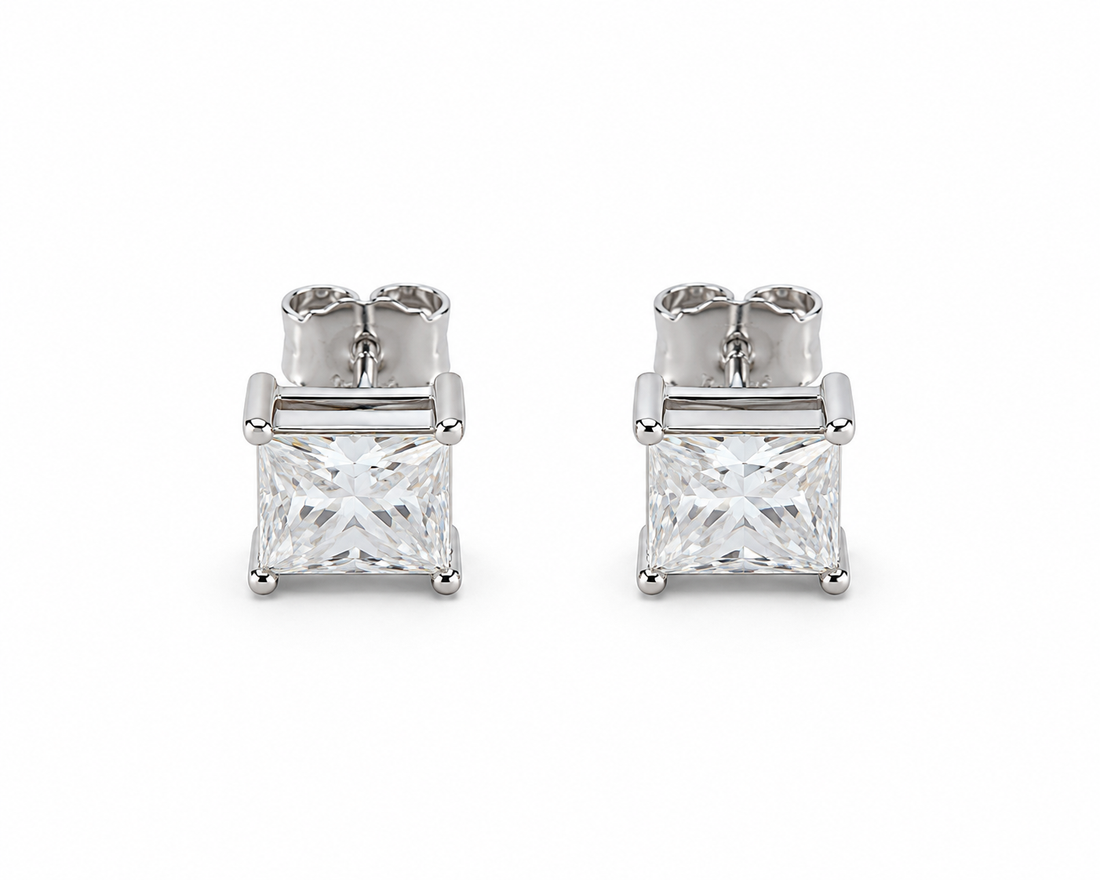 A pair of silver stud earrings featuring square princess-cut clear gemstones in a four-prong setting, shown on a clean white background.